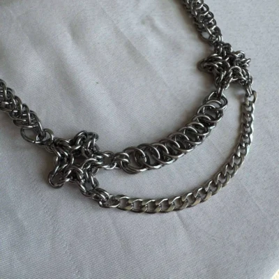 Marlowe Layered Chainmail Necklace Detail Marlowe layered chainmail necklace detail with woven rings and draped steel chain