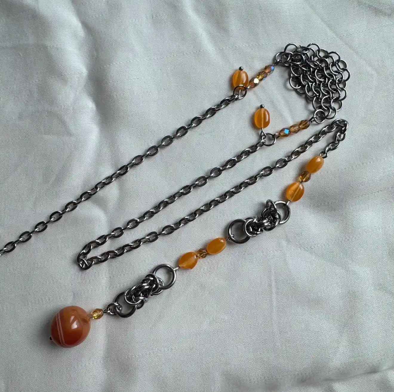 Orange gemstone face chain with silver chainmail and beaded details