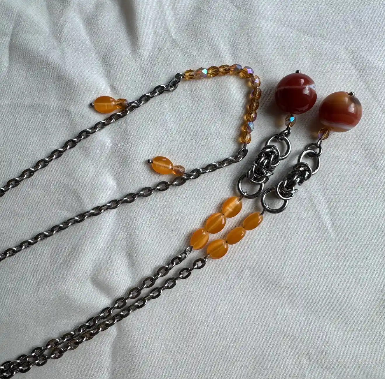 Silver face chain with orange gemstone beads and dangling side chains
